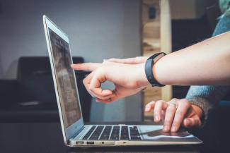 Pessoa trabalhando em um notebook com código na tela